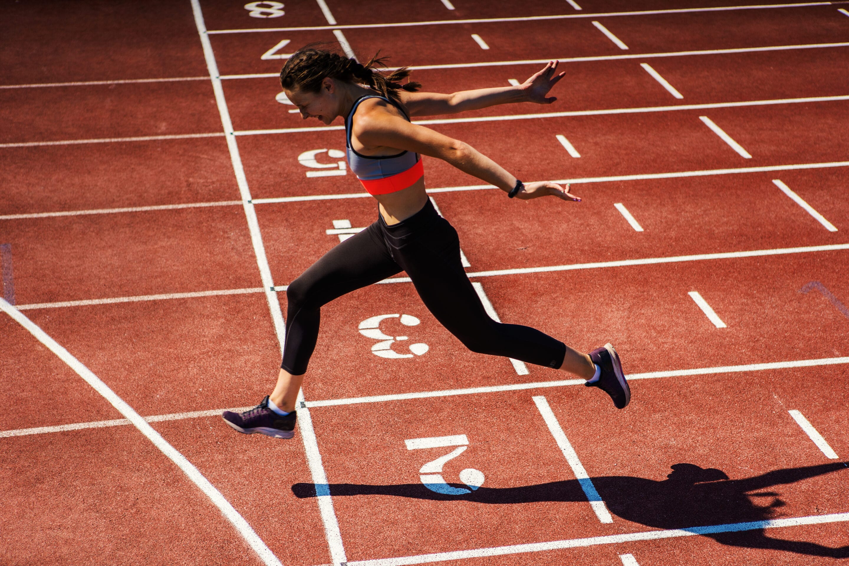Teenage athlete finishing race on running track